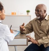 Healthcare, Geriatric Medicine, Medical Check Up. Senior man visiting doctor telling about health complaints, female gp or nurse writing personal information, filling form listening to elderly patient