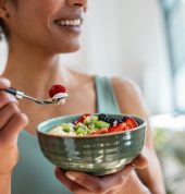 Close,Up,Of,Athletic,Woman,Eating,A,Healthy,Fruit,Bowl